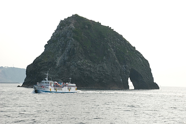 Impressive Elephant Rock off Ulleungdo's North shore dwarfs a nearby tour boat